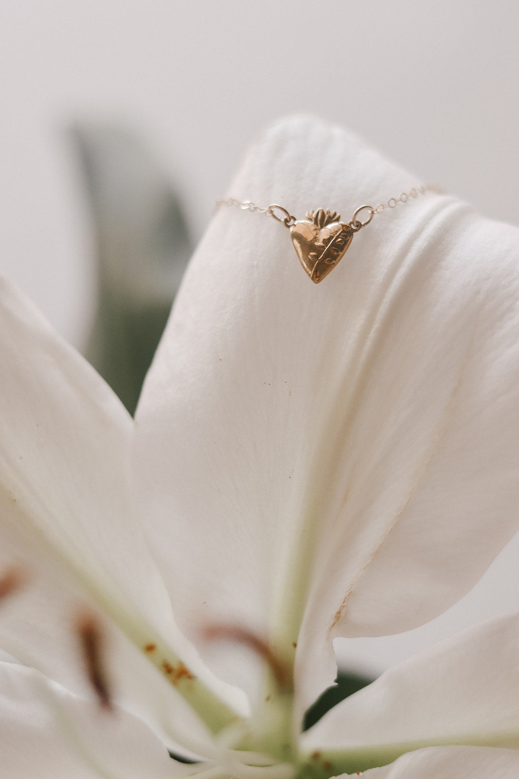Gold-tone heart charm necklace with small crown-like detail