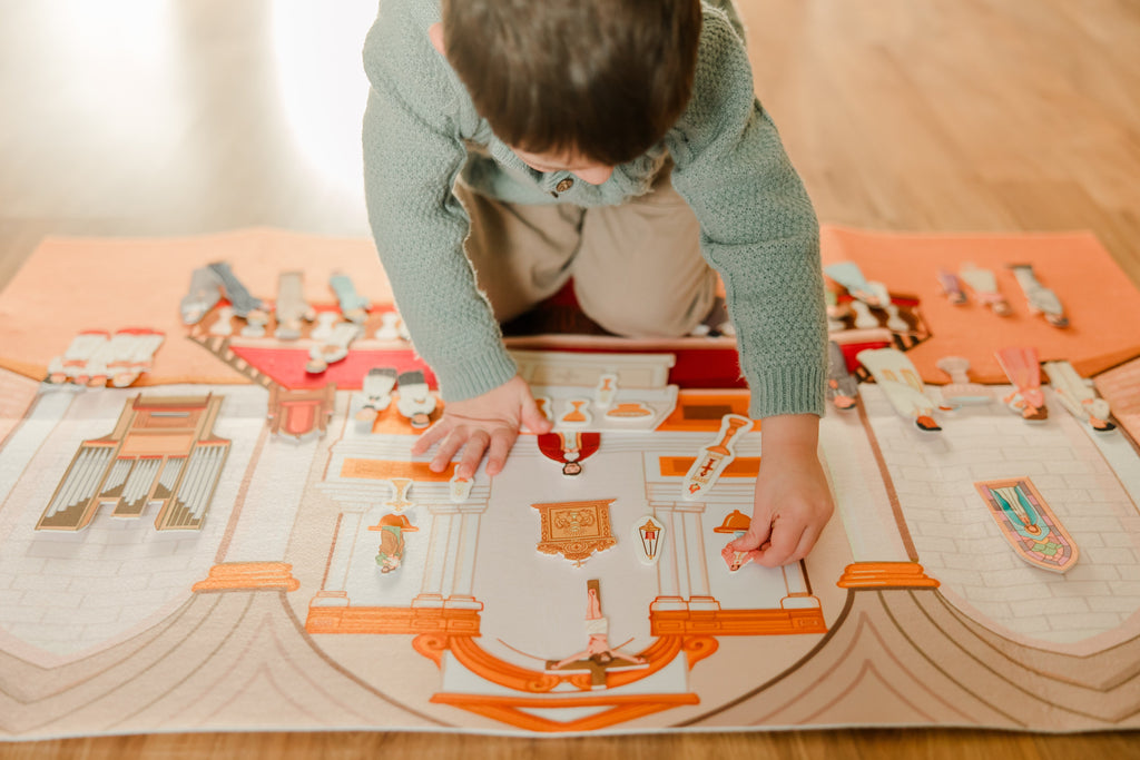 Child arranging pieces on church play story board with altar, pews, and figures