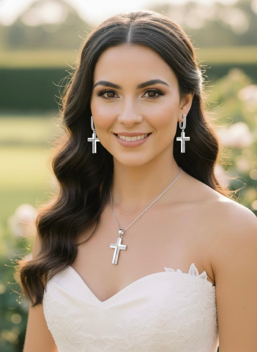 Silver cross pendant necklace and cross earrings worn by a woman