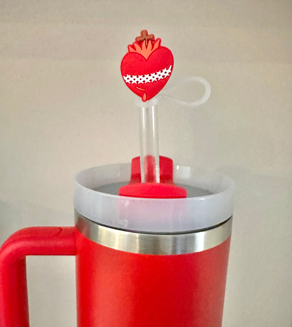 Close-up of red heart straw topper with crown and white loop on a clear straw