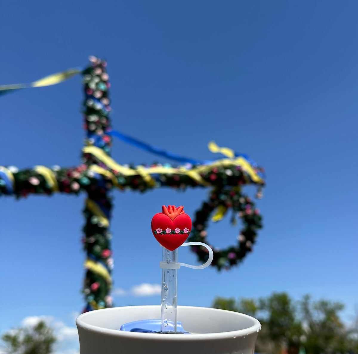 Red heart straw topper with crown design and white loop on a clear straw holder