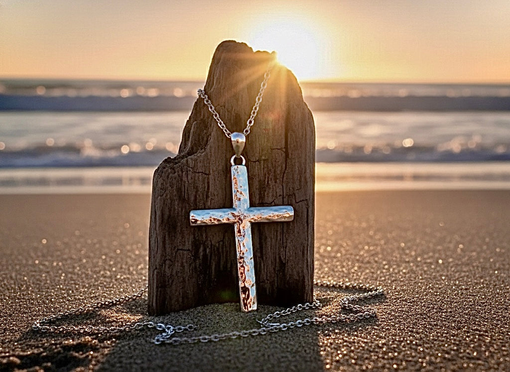 Sterling silver cross pendant necklace hanging on a chain