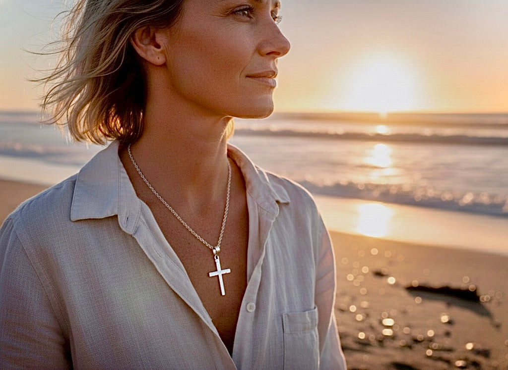 Sterling silver cross pendant necklace worn on a woman's neckline