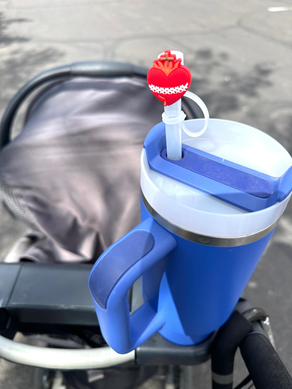 Red heart straw topper with crown and white loop on a blue insulated cup straw