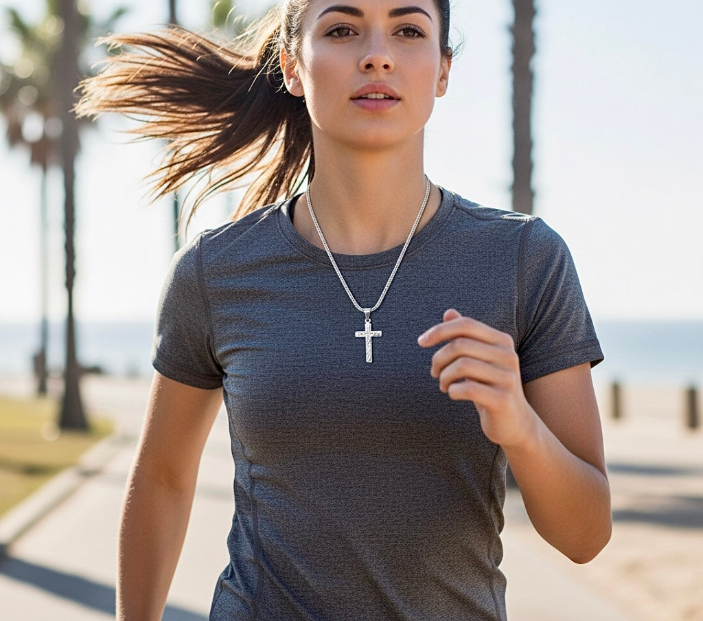 Silver cross pendant necklace worn by a woman, pendant centered on chain