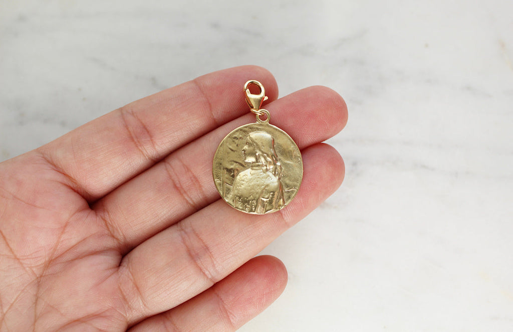 Gold medallion pendant with St. Joan of Arc relief, oval frame, loop bail