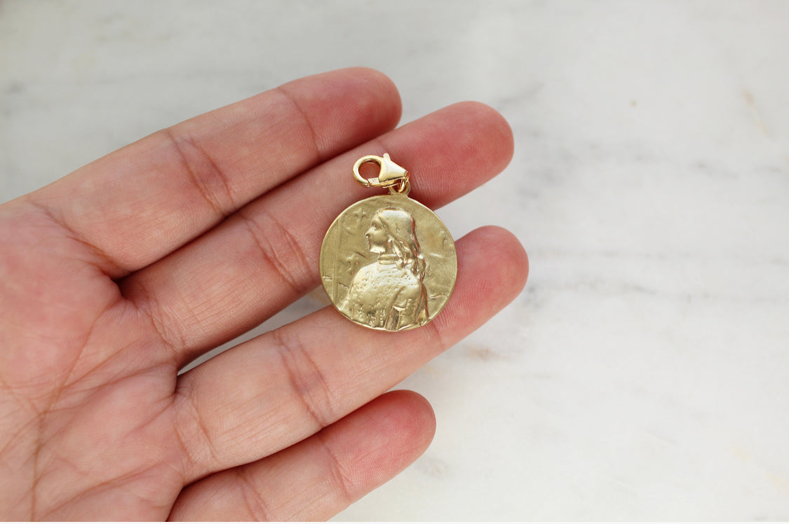 Gold medallion pendant with St. Joan of Arc relief, top loop bail, side view
