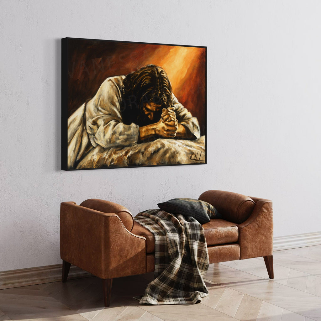 Framed giclée print of a praying man with clasped hands above a brown sofa
