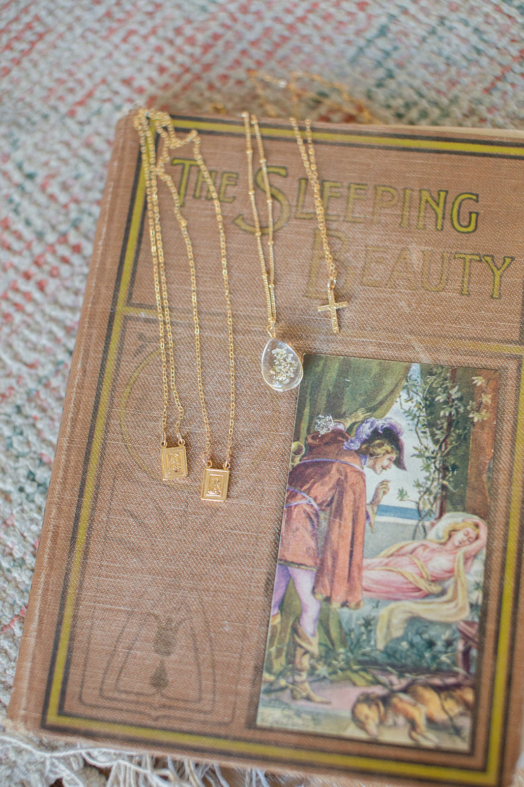 Gold cross necklace with chain on gift card, multiple cross pendants visible