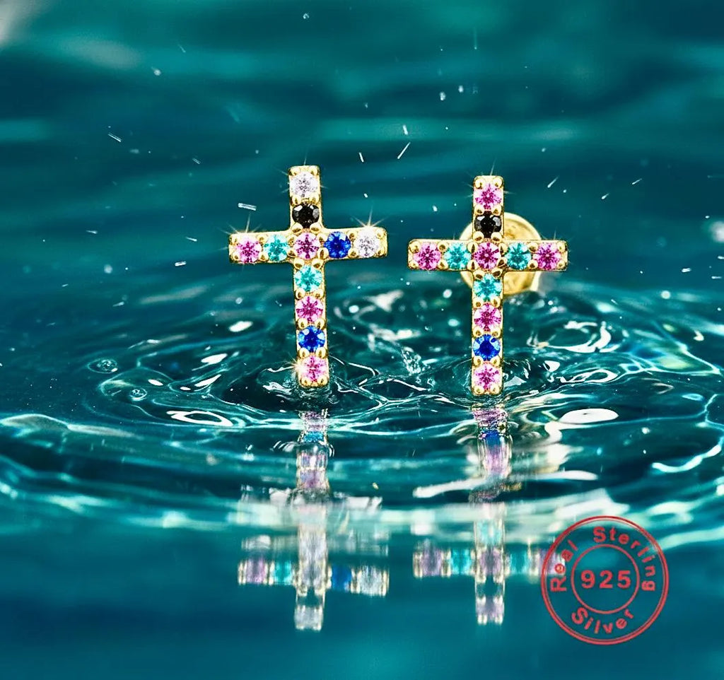 Cross stud earrings with multicolor crystal inlay, reflective surface background