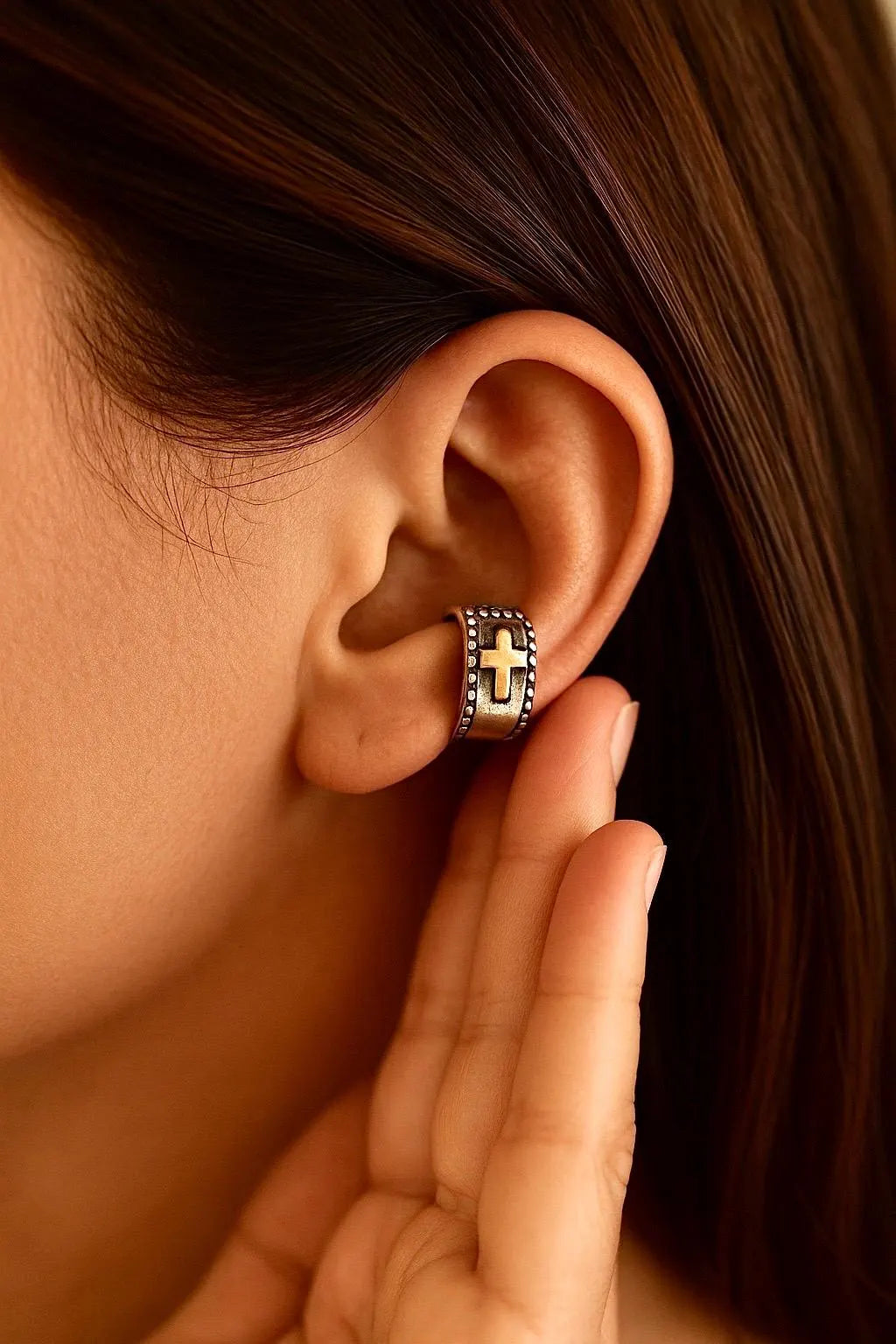 Sterling silver cross wrap cuff earring on ear, gold cross and dark blue stones