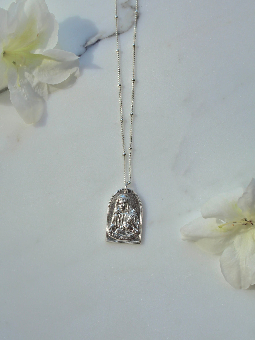 Sterling silver Saint pendant necklace with oval charm hanging on chain
