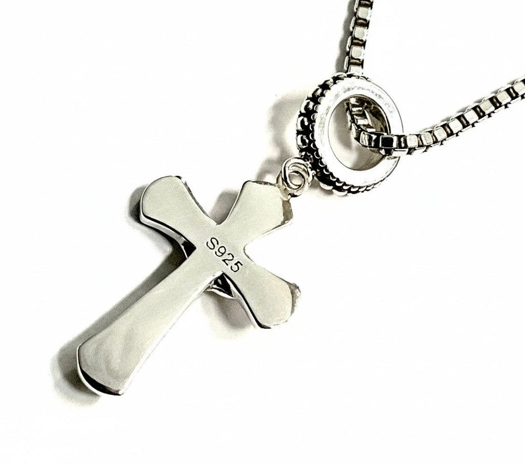 Sterling silver crucifix pendant with S925 marking and chain, close-up.