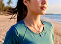 Silver crucifix necklace with small pendant on a fine chain at the neckline.