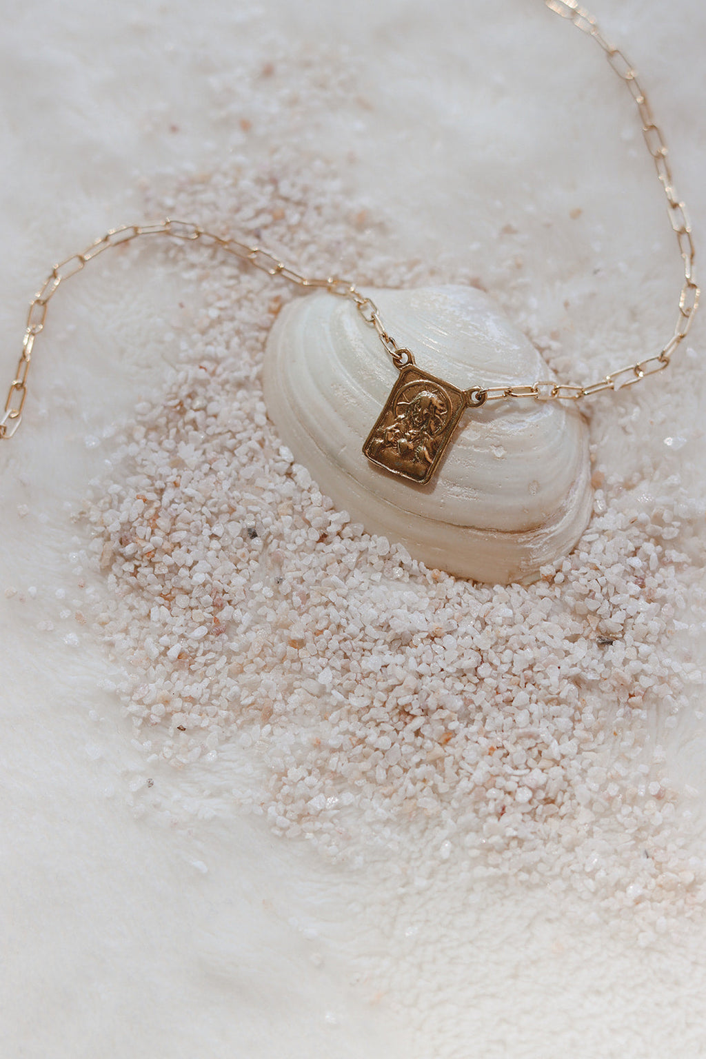 Scapular charm necklace with gold-tone chain and shell-style oval centerpiece charm