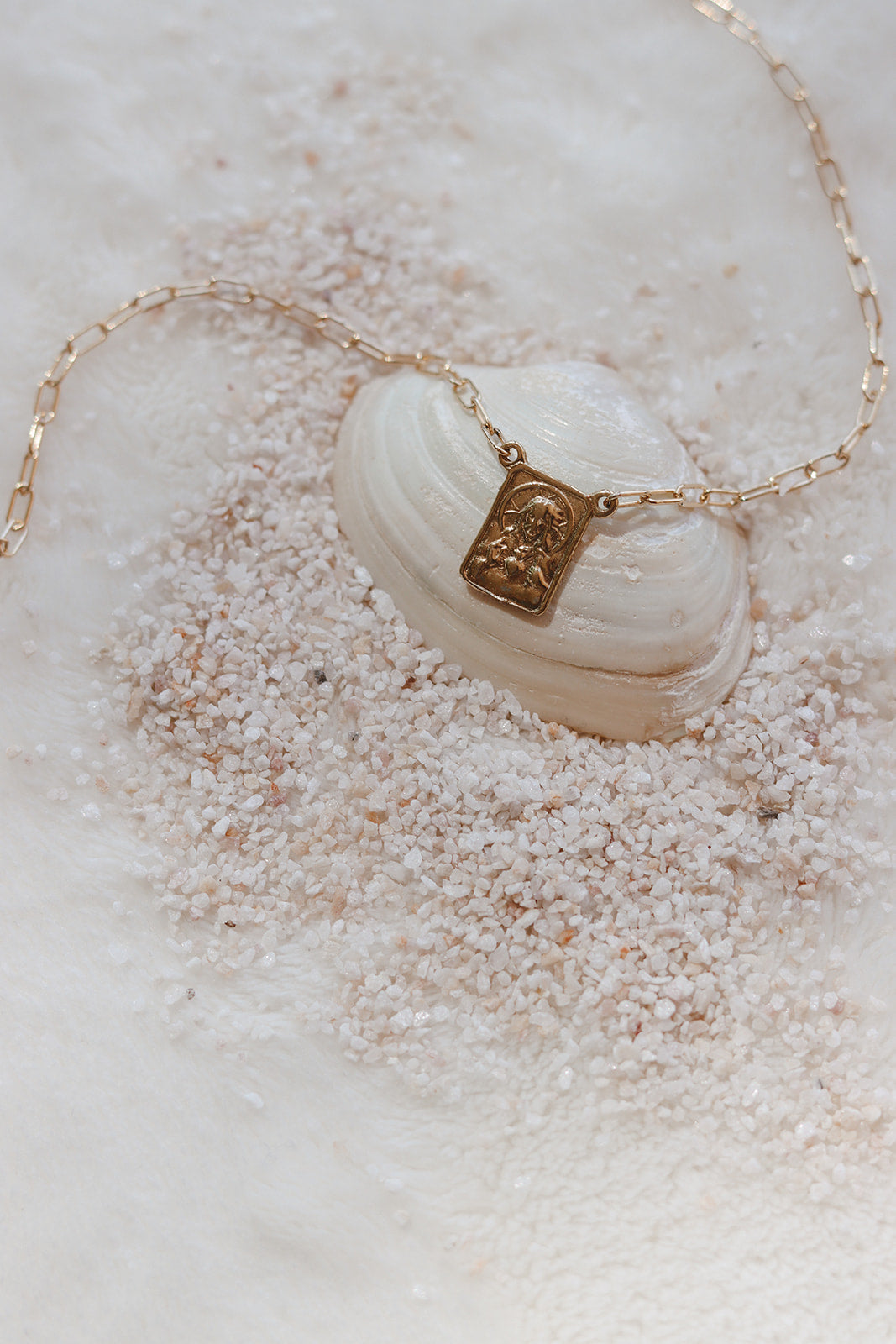 Scapular charm necklace with gold-tone chain and shell-style oval centerpiece charm