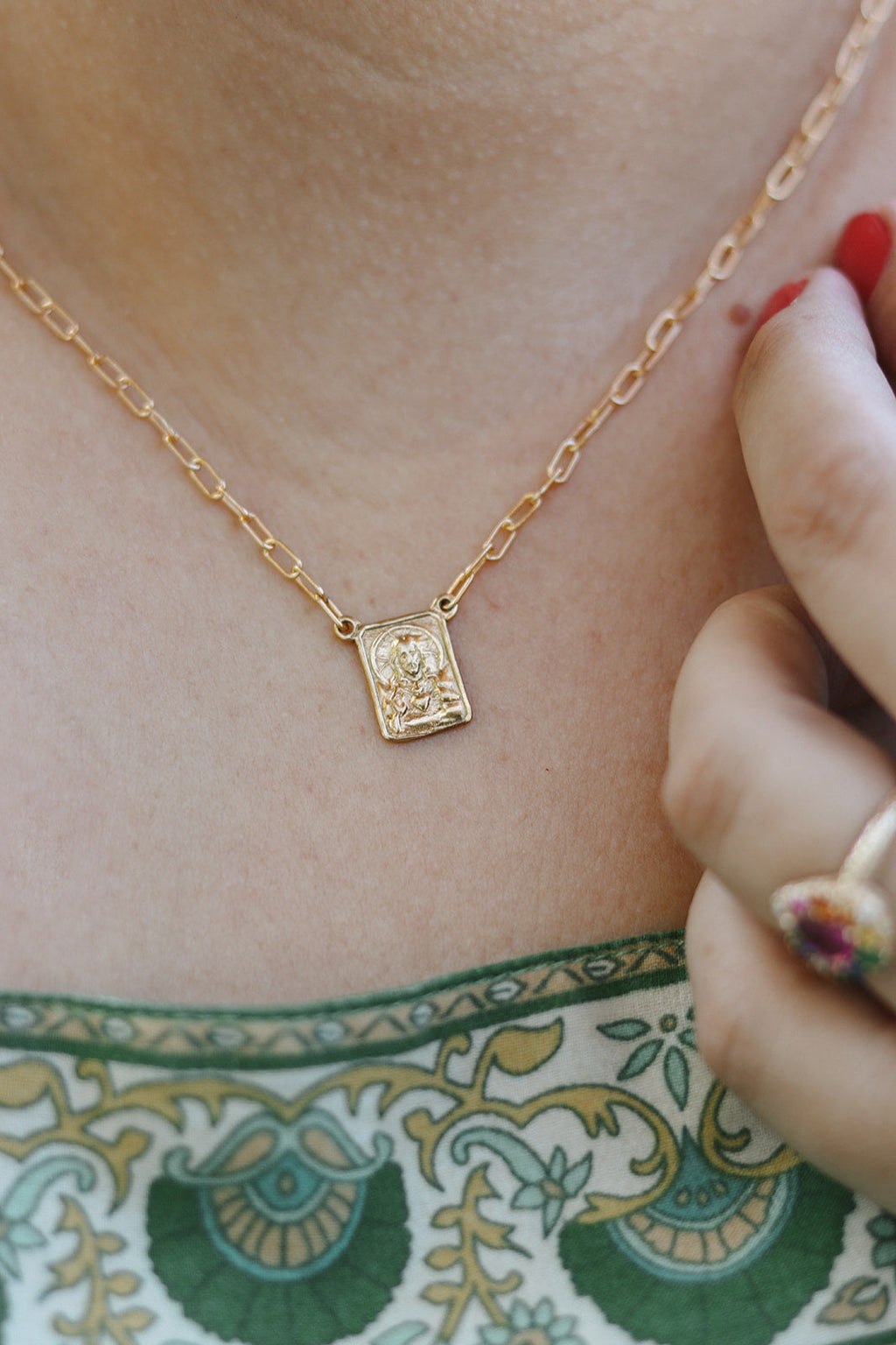 Gold paperclip scapular necklace with small square pendant at neckline