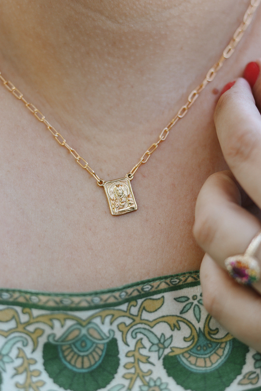 Gold paperclip scapular necklace with small square pendant at neckline