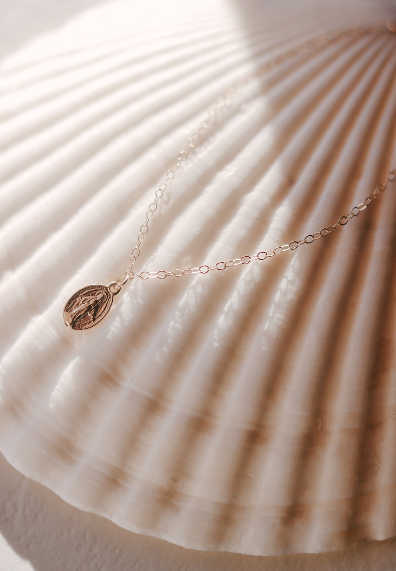 14K gold bracelet detail with oval miraculous medal charm on link chain