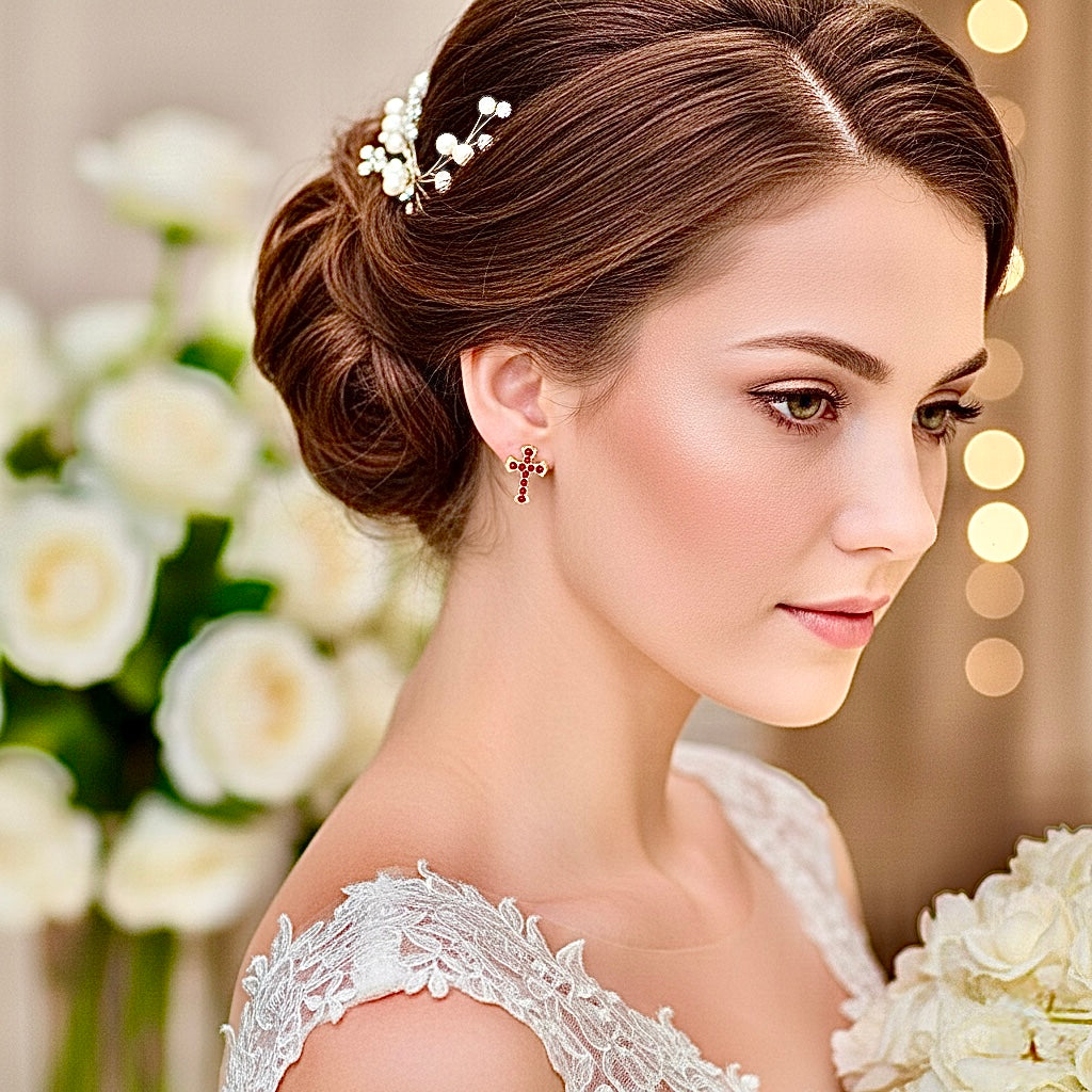 Gold cross stud earrings with red round CZ stones, worn with a floral hairpin