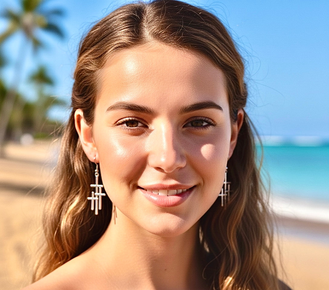 Silver triple cross drop earrings with stacked crosses, dangling from ear hooks