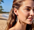 Silver triple cross drop earrings on a woman’s ear, vintage stacked cross design