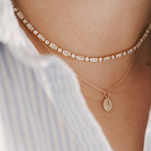 14k gold medal necklace with small oval pendant and thin chain layered look