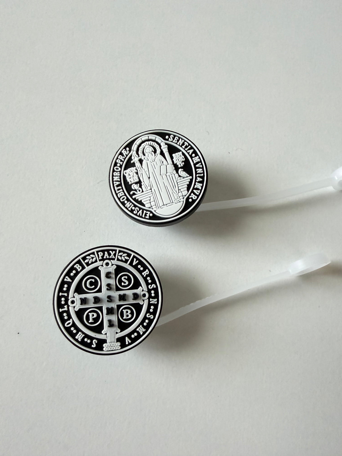 Two St. Benedict medal straw topper discs with white straw tubes