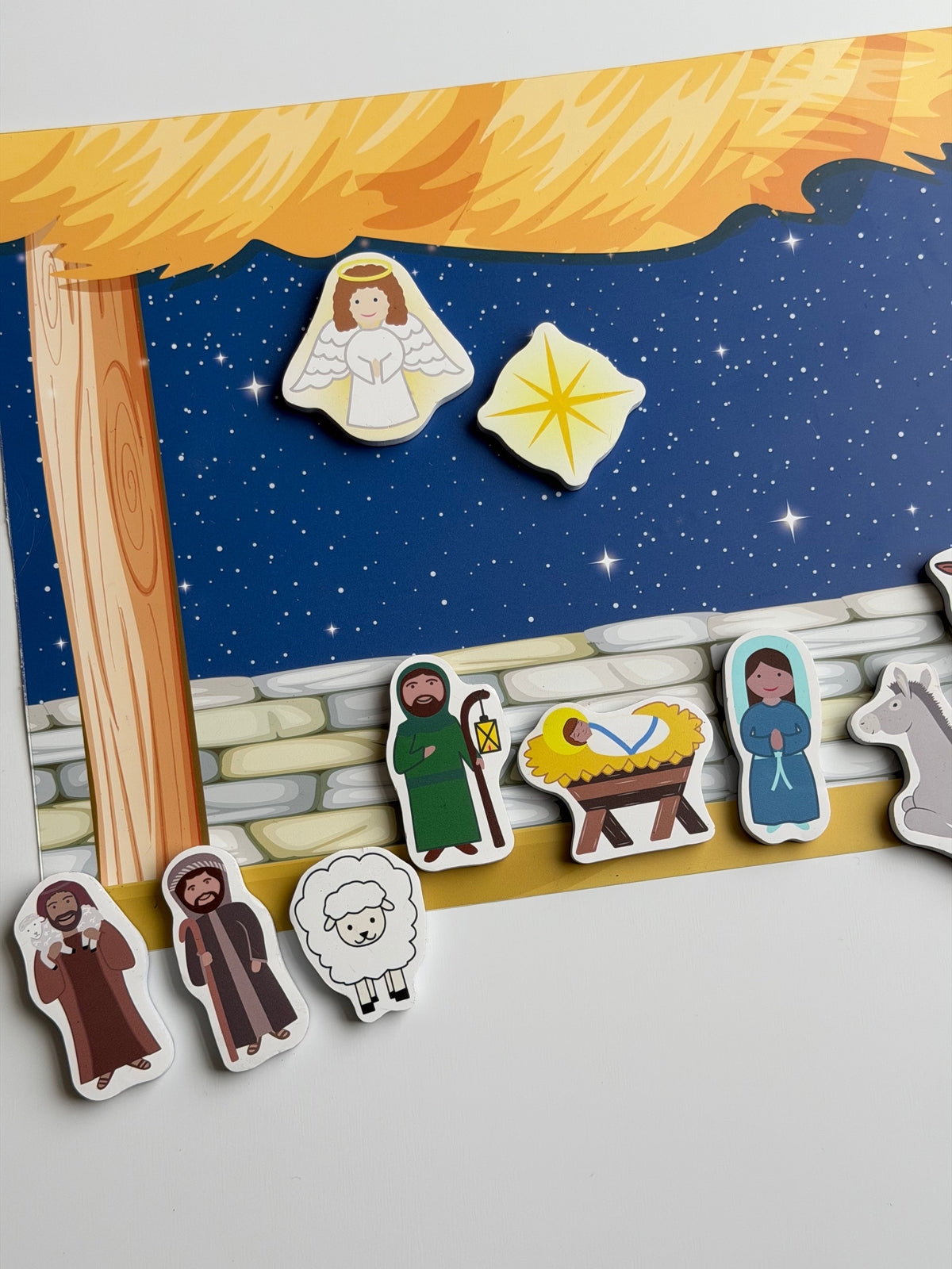 Nativity magnet set detail: angel and star magnets over manger with shepherd figures