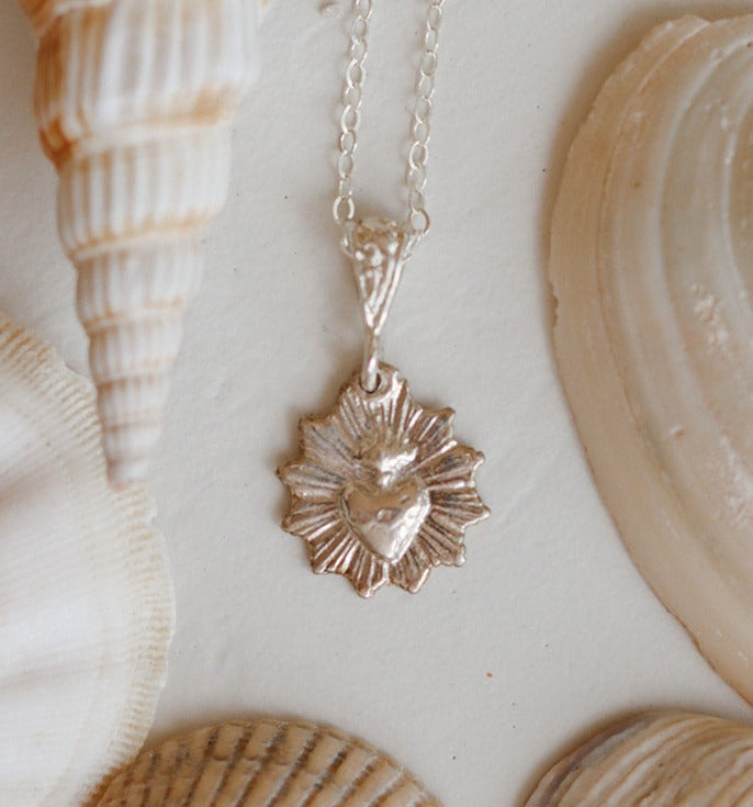 Silver scalloped heart pendant on thin chain, close-up detail