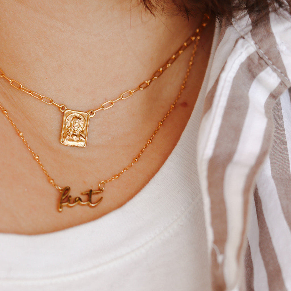 Scapular charm necklace with gold-tone chain and rectangular medallion pendant