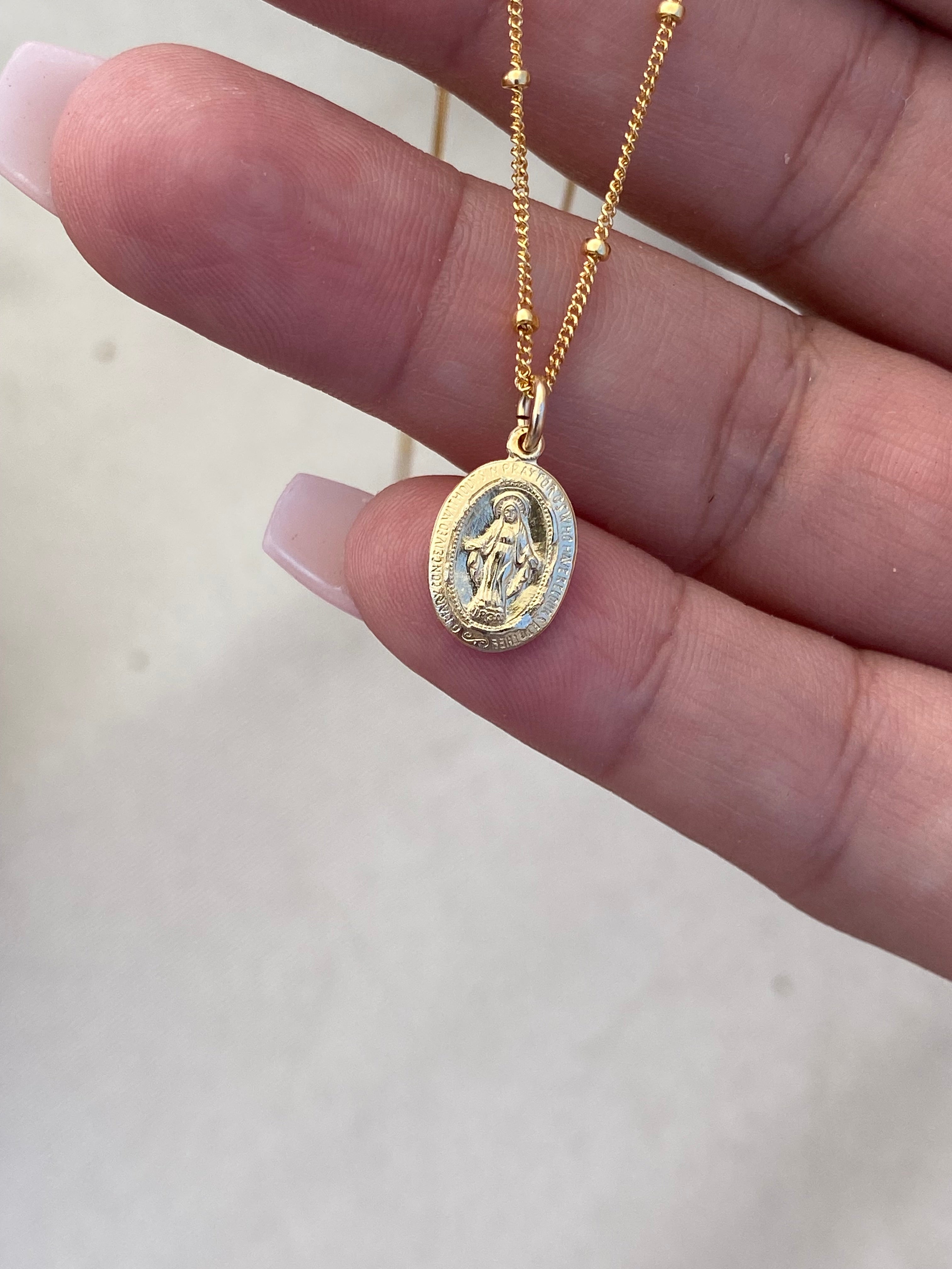 Gold-tone chain necklace with oval religious medal pendant