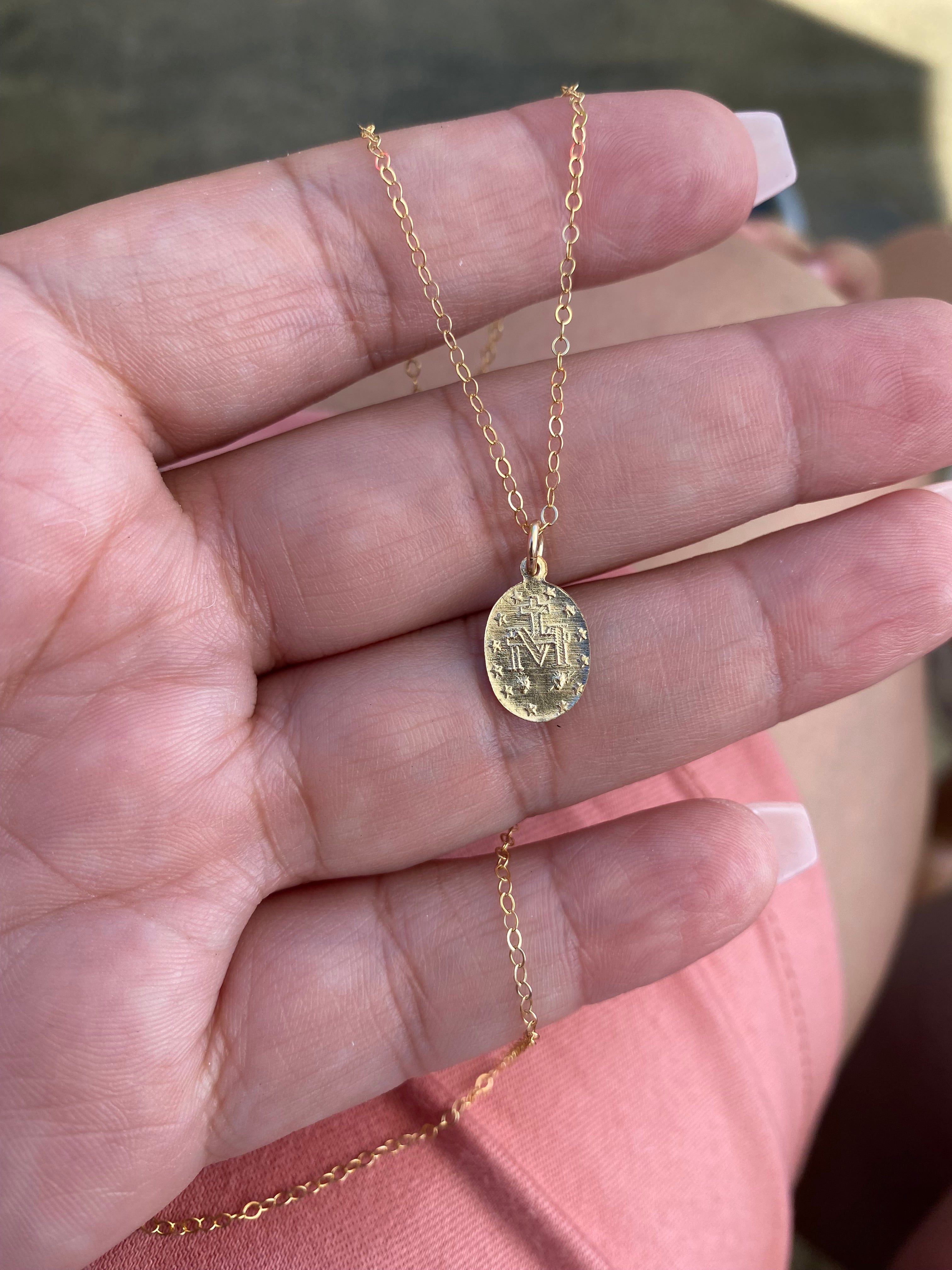 Gold-tone medal necklace with circular pendant on a curb chain