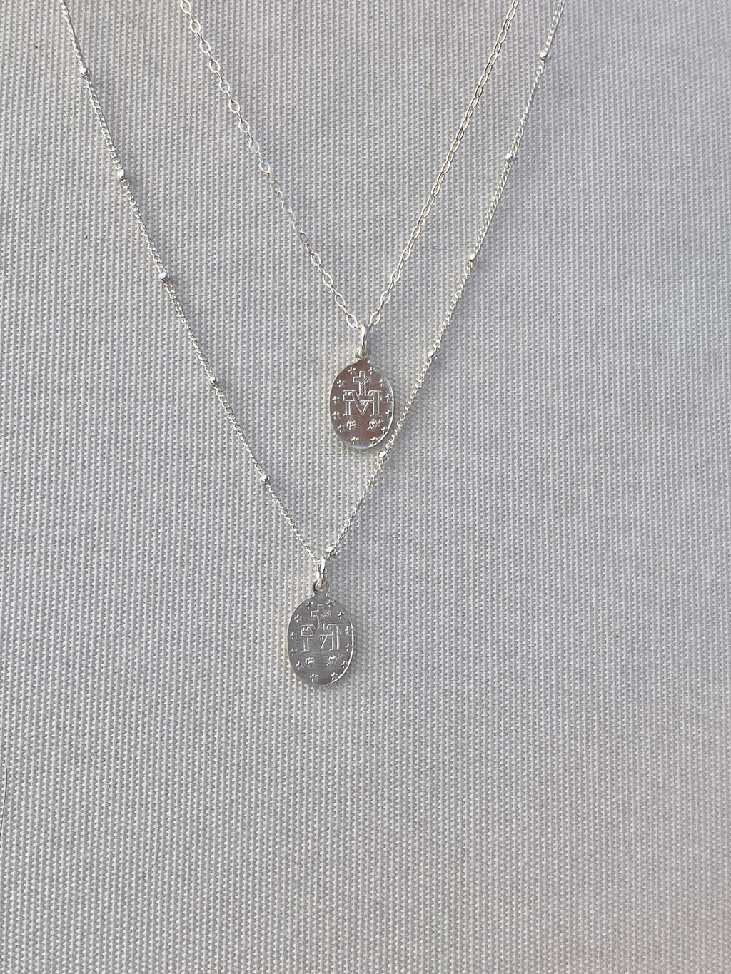 Silver miraculous medal necklaces with oval pendant and thin chain links