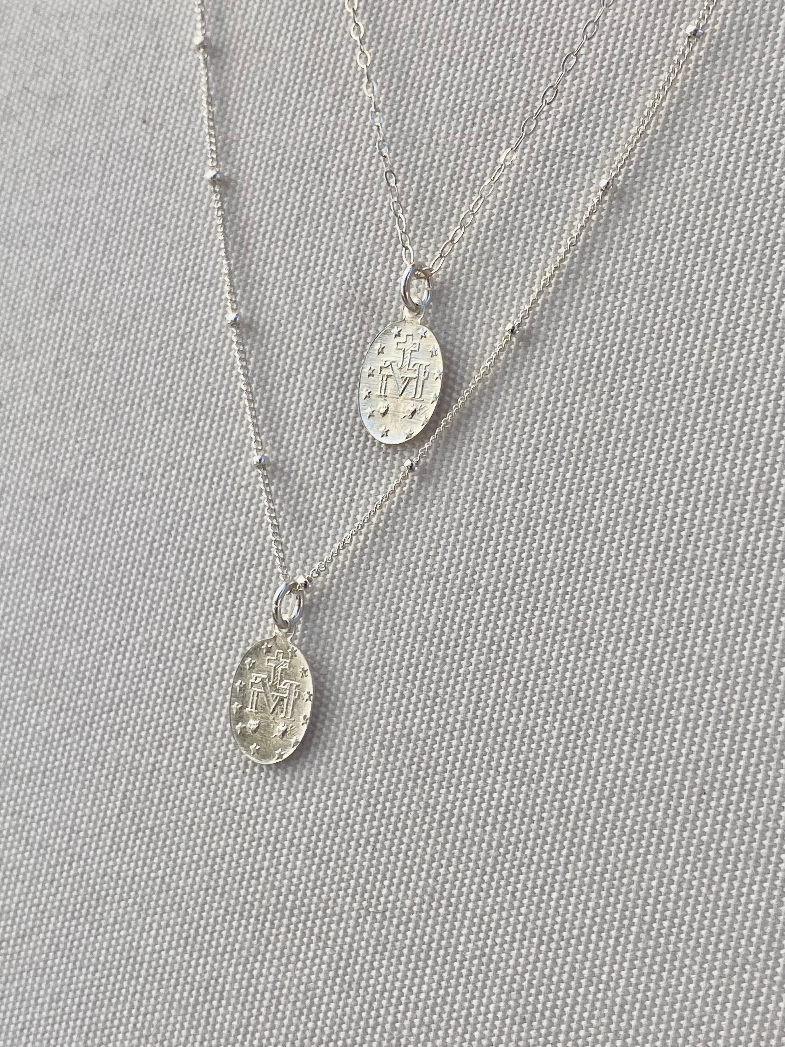Silver miraculous medal necklaces, two oval pendants on thin chain