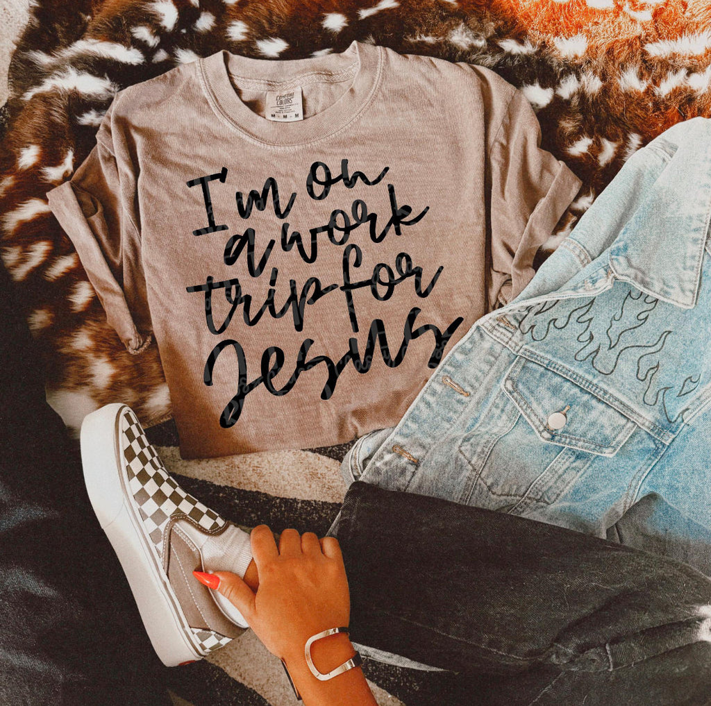 Tan crew-neck tee with black script “I’m on a work trip for Jesus” print