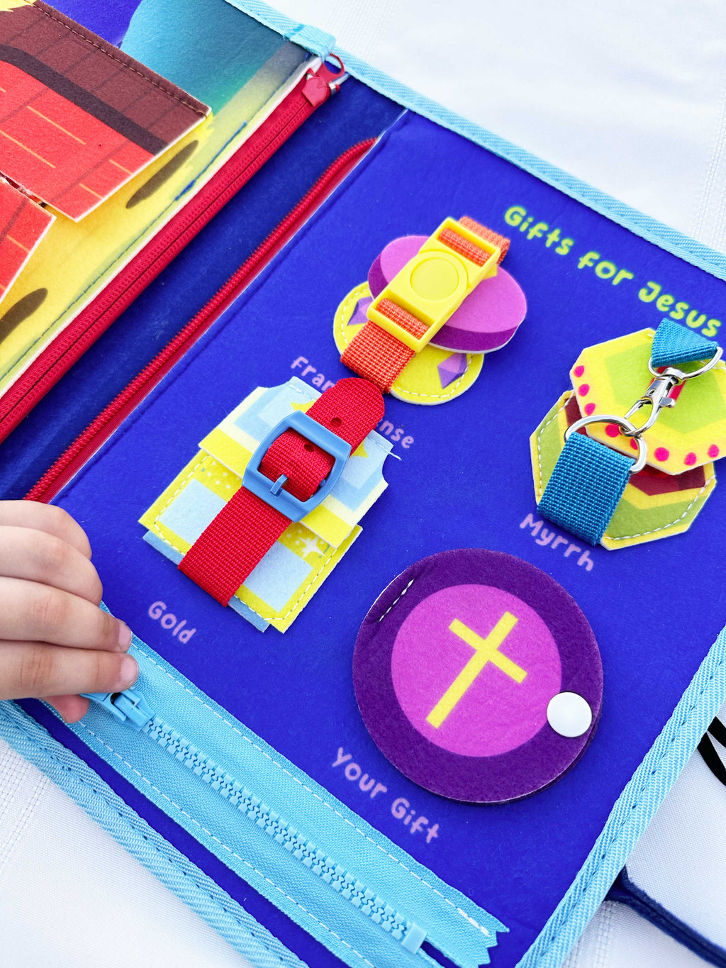 Nativity busy book page with felt cross, loops, and fabric learning tabs
