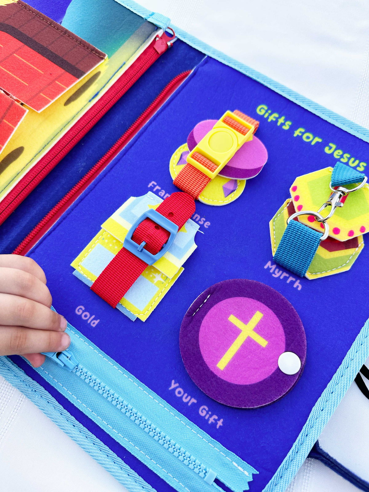 Nativity busy book page with felt cross, loops, and fabric learning tabs