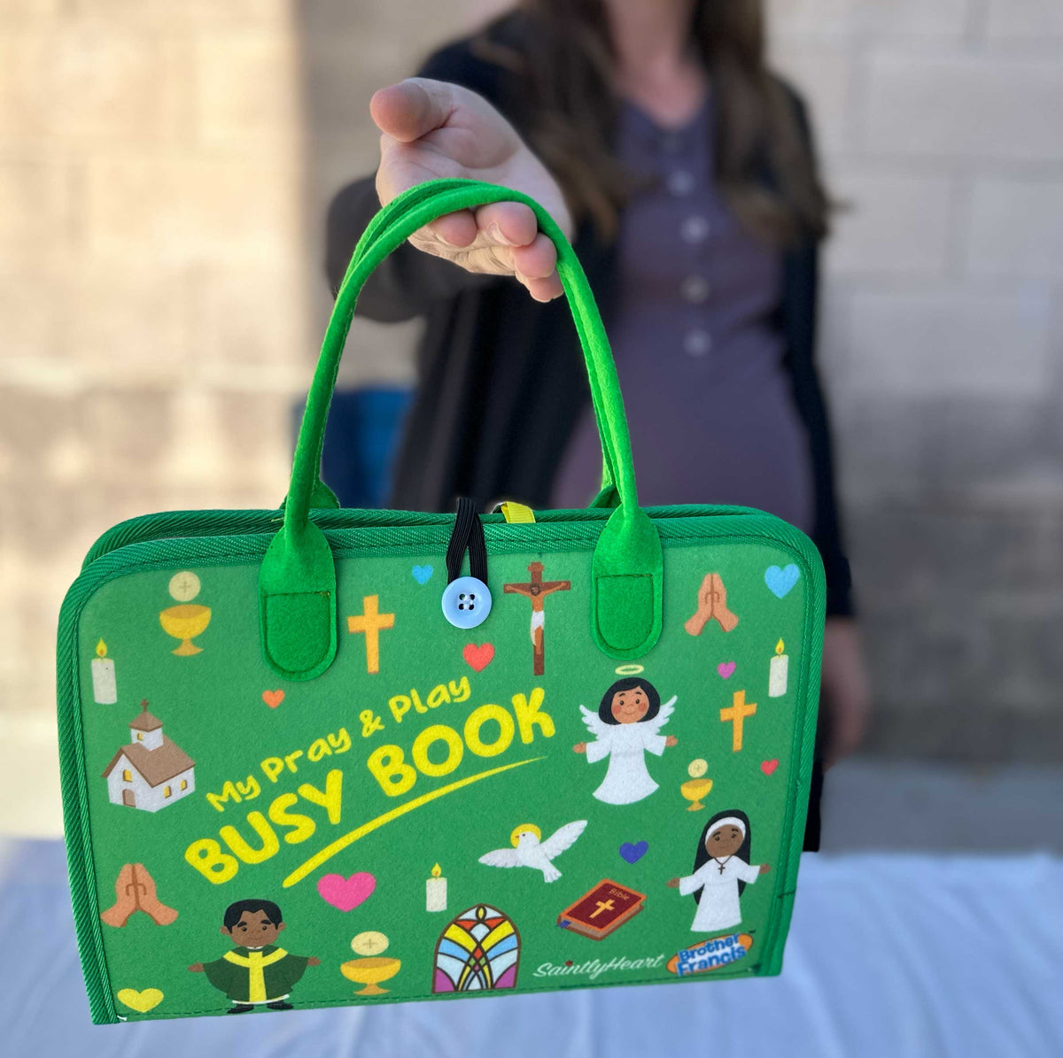 Green felt Catholic busy book in carry bag, featuring cross and “Busy Book” title