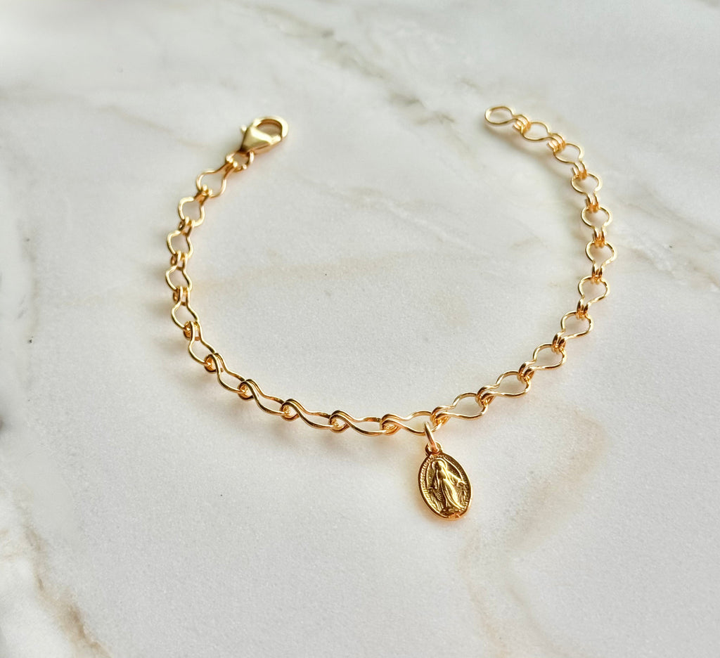 Gold-tone bracelet with oval medal charm and lobster-style clasp at top