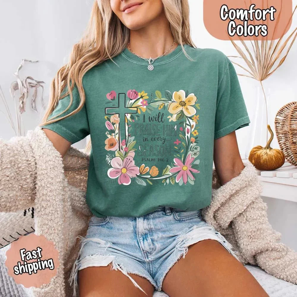 Green crewneck tee with floral cross graphic and blooms, “I will praise Him in every season”