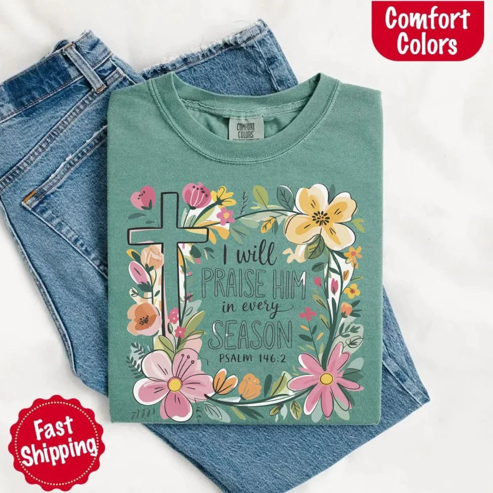 Teal-green crewneck tee with floral cross and flowers, “I will praise Him in every season”