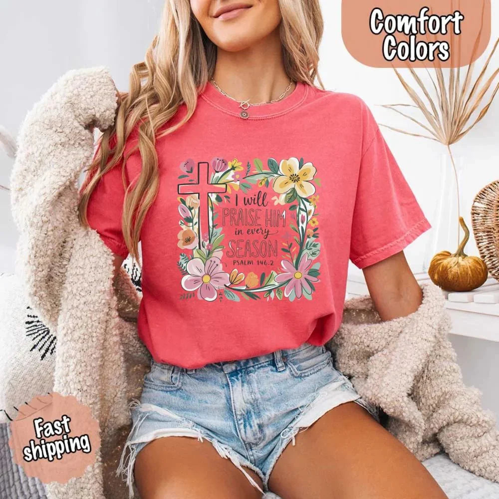 Coral pink comfort tee with floral cross frame and “I will praise him in every season” print