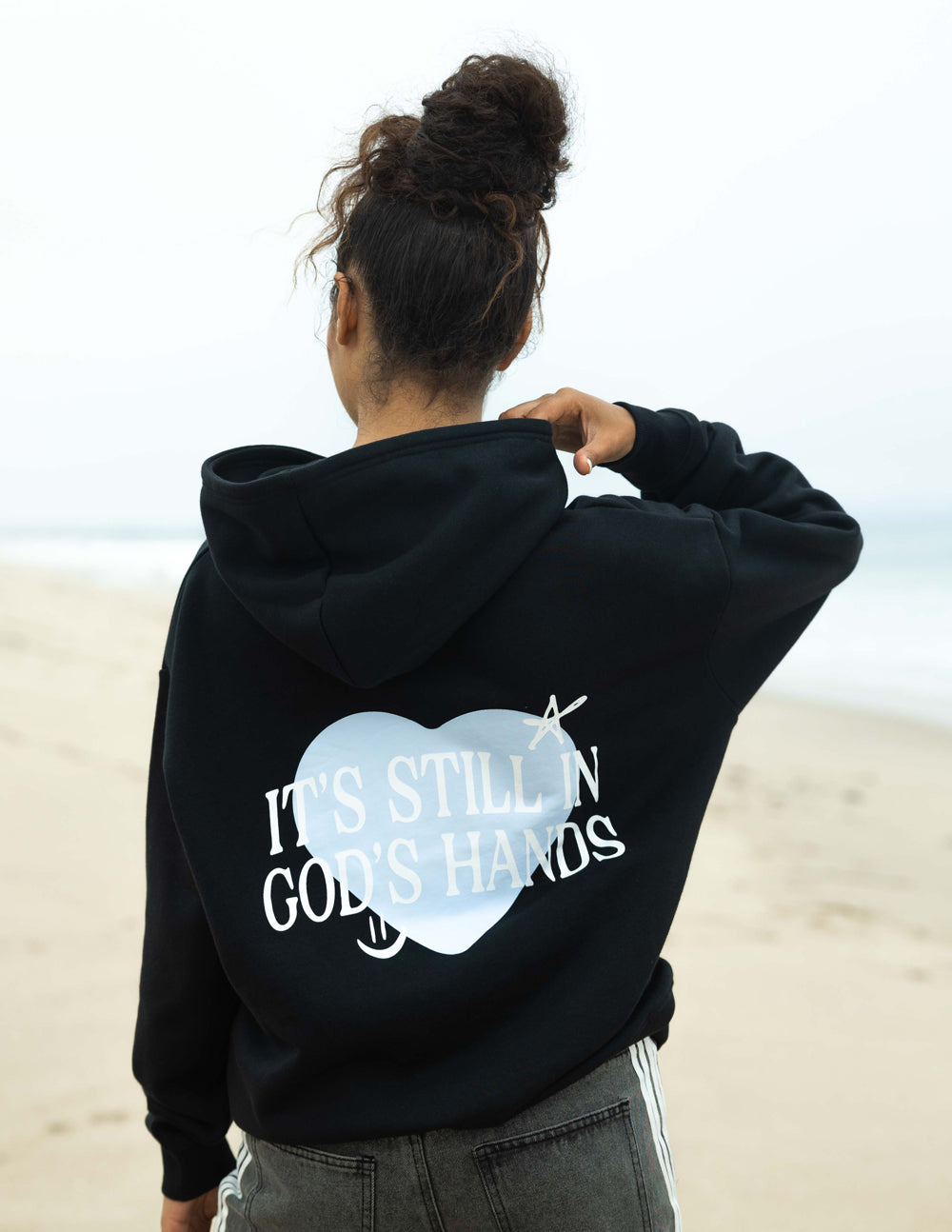 Black unisex hoodie with large heart graphic and text on the back