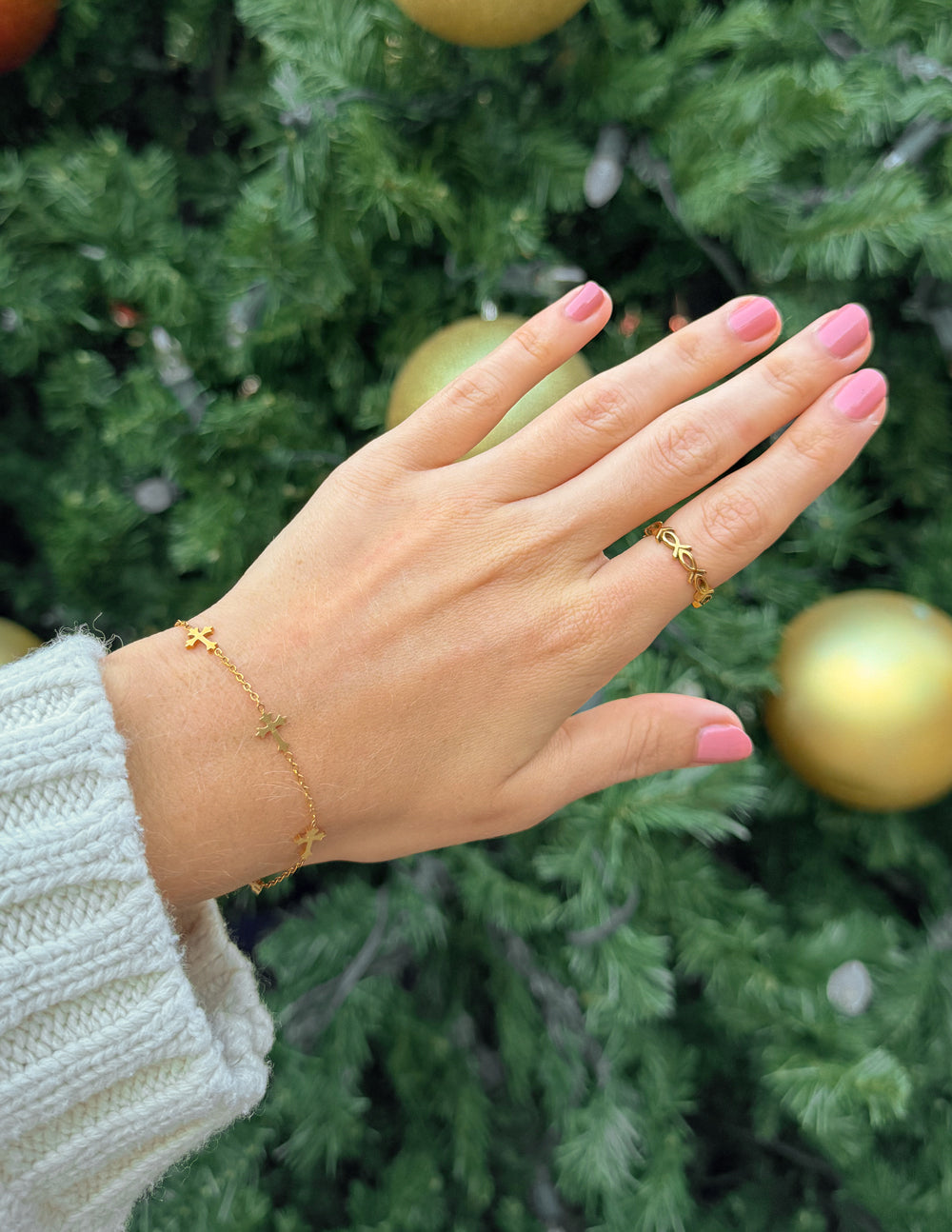 Gold infinity fish ring on hand, delicate fish-link design at the finger.