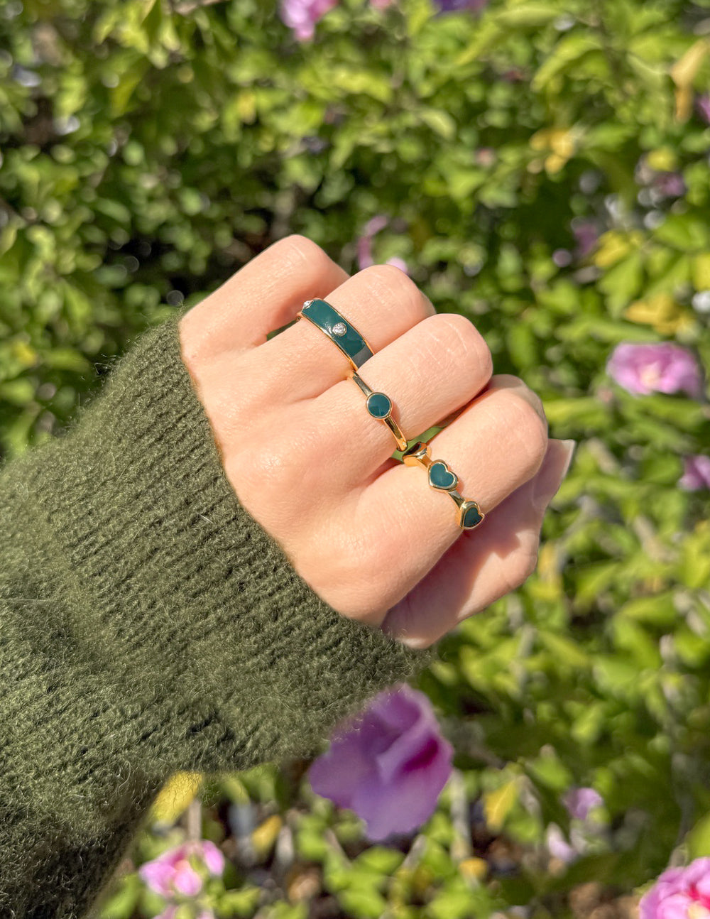 Gold-tone stacking ring set with teal-green round stones and curved bands