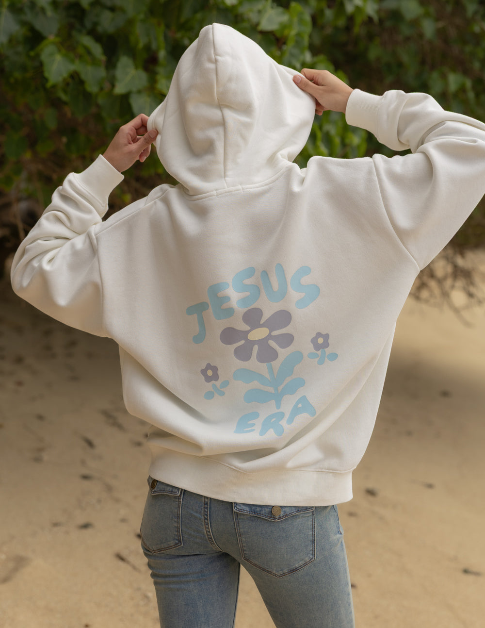 Off-white unisex hoodie back view with large 'JESUS ERA' floral text graphic