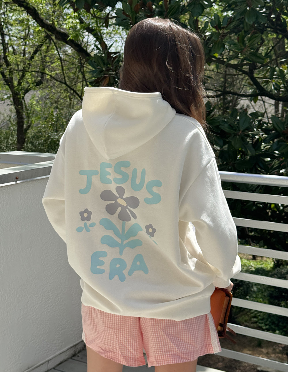 Off-white unisex hoodie back view with 'JESUS ERA' floral text graphic