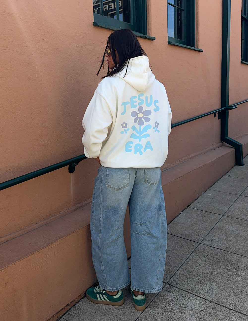 Off-white unisex hoodie back view with 'JESUS ERA' floral text print