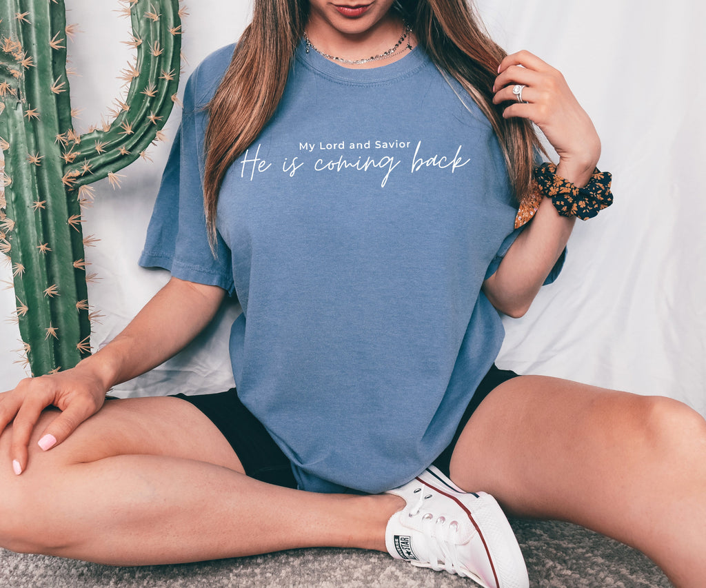 Blue T-shirt with white 'He is coming back' script on the front